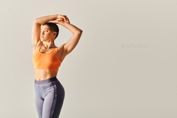 Motivated Girl Stretching On A Grey Background Stock Photo