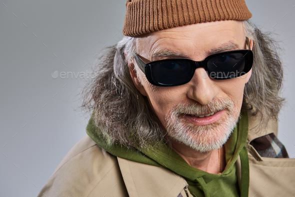 Portrait of man with grey beard wearing spectacles and hat stock photo
