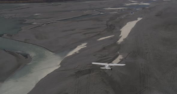 Helicopter aerial shot following RV down street, Alaska, overcast, drone footage alt