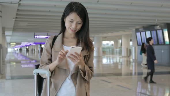 Woman use of mobile phone in airport  alt