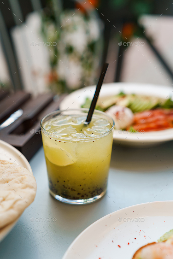 Kiwi Basil Gin Smash cocktail on the table Stock Photo by