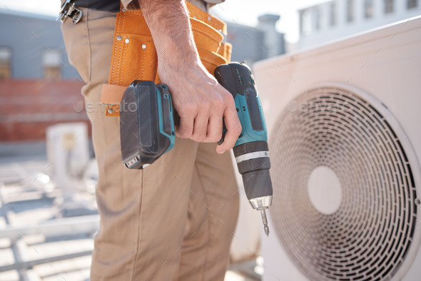 Hands, man and outdoor for air conditioner maintenance, roof and building in city, drill or constru