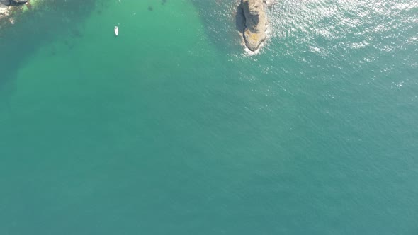 Aerial View From Above on Calm Azure Sea and Volcanic Rocky Shores alt