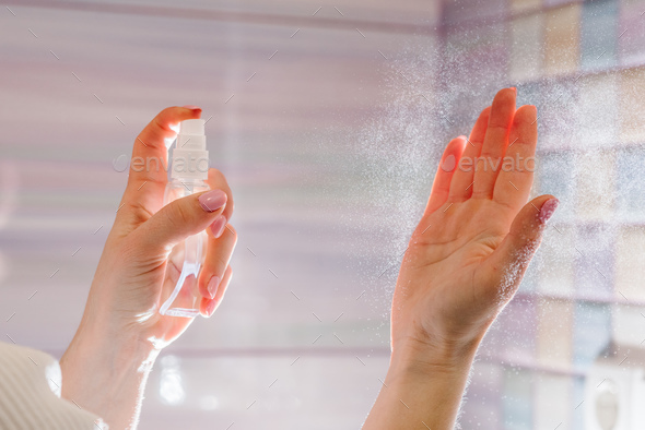 Hands applying alcohol spray or anti bacteria spray. Personal hygiene concept. Coronavirus.