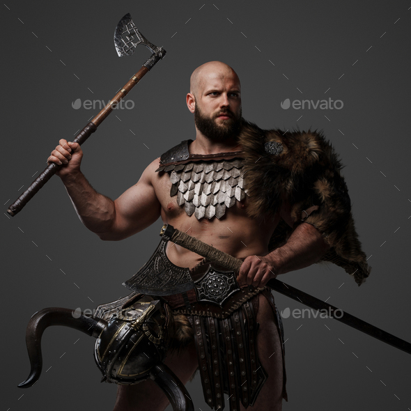 Viking man in a beard and bald head against a gray background