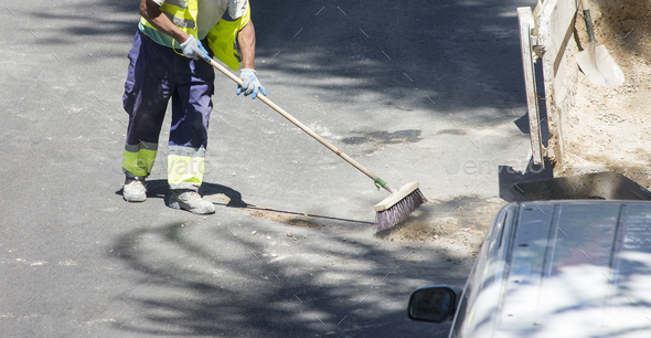 A group of construction workers are working on a street. - Stock Photo - Images