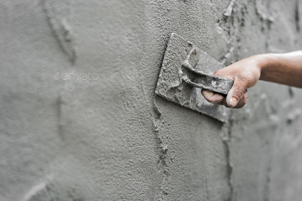 Hand plasterer plastering cement wall background, hand worker brush rough concrete floor for smooth