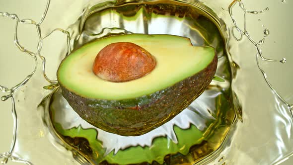 Super Slow Motion Shot of Fresh Avocado Falling and Splashing Into Oil at 1000 Fps alt