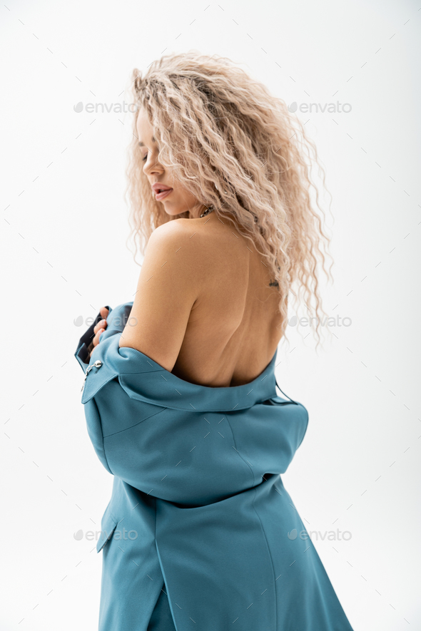 erotic and charming woman with wavy ash blonde hair wearing blue