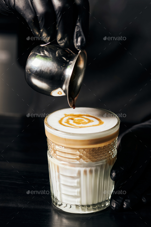 latte macchiato, pouring espresso in glass, pitcher with coffee, milk foam,  energy and caffeine Stock Photo by LightFieldStudios