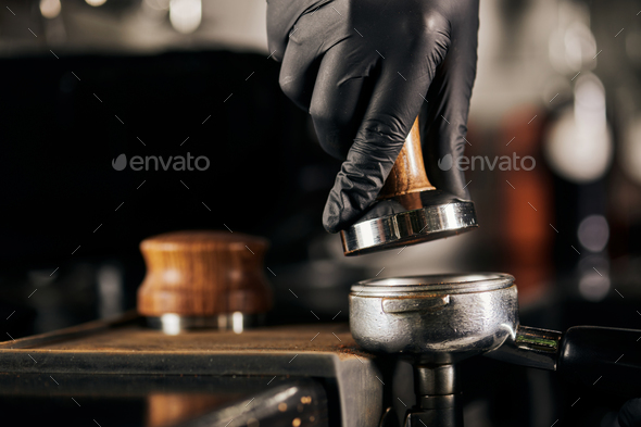 barista holding tamper near portafilter with grinded coffee, espresso, manual  press Stock Photo by LightFieldStudios