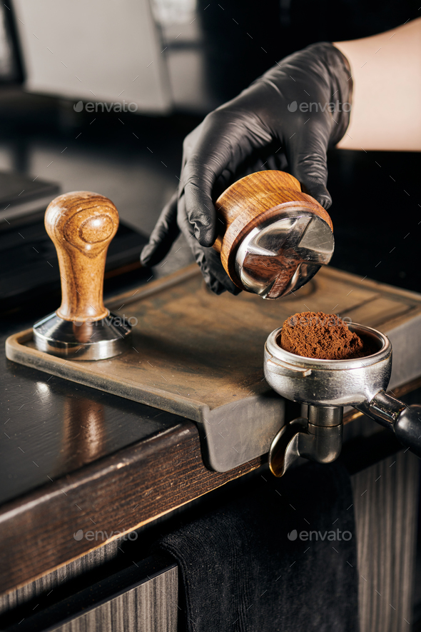 barista holding tamper near portafilter with grinded coffee, espresso, manual  press Stock Photo by LightFieldStudios