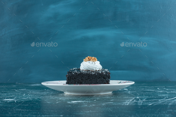 Chocolate cake on a platter on blue background