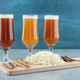 Three glasses of beer with fish and cheese on wooden cutting board - PhotoDune Item for Sale