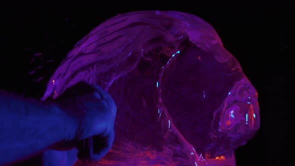 Carving the Mane of an Ice Sculpture of a Lion Artist Working with a Chisel alt