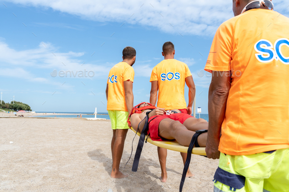 Medical staff transporting an injured man with a stretcher