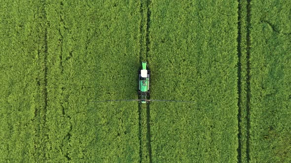 Tractor With A Trailer Of Fertilizers Sprays Chemicals On A Green Rural Field alt