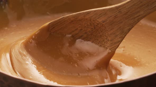 Stirring melted caramel, closeup food shot. 