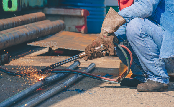 Cropped image of welder is welding galvanized steel pipes with acetylene gas welding torch machine