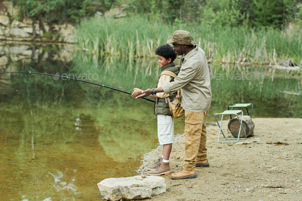 Dad teaching his son to catch a fish Stock Photo by AnnaStills