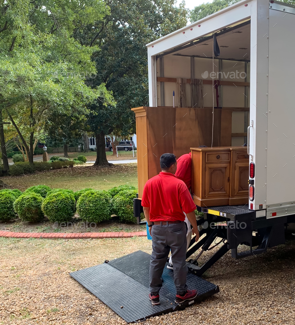 Moving company crew placing furniture in moving truck to be covered and protected during transfer