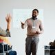 Happy black teacher pointing at student who wants to ask question during adult education class. - PhotoDune Item for Sale