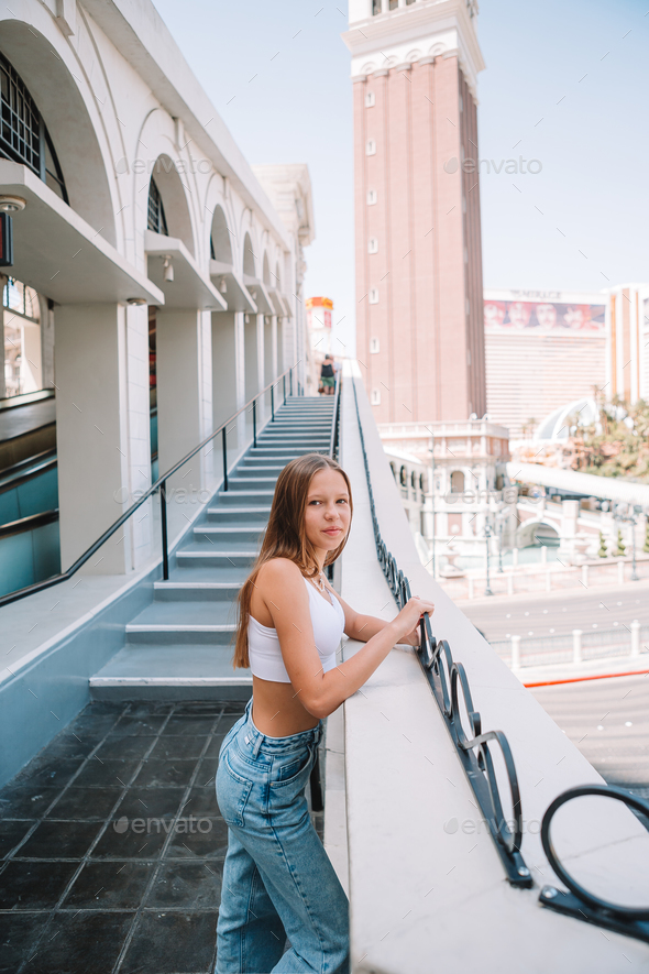 Beautiful young girl background the famous hotel in Las Vegas, standing in  the busy city. Famous Stock Photo by travnikovstudio
