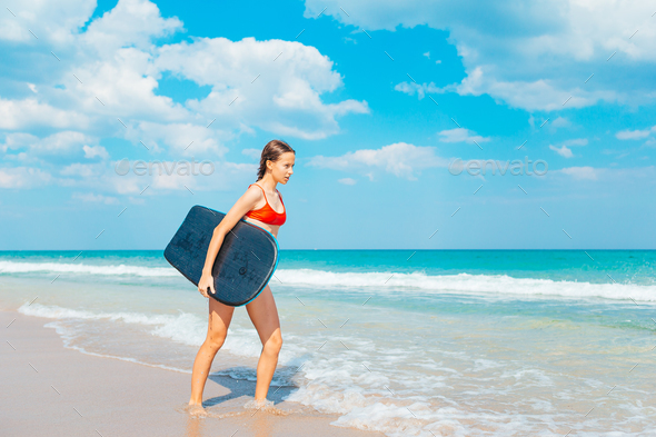 Adorable teen girl on the beach having fun in shallow water