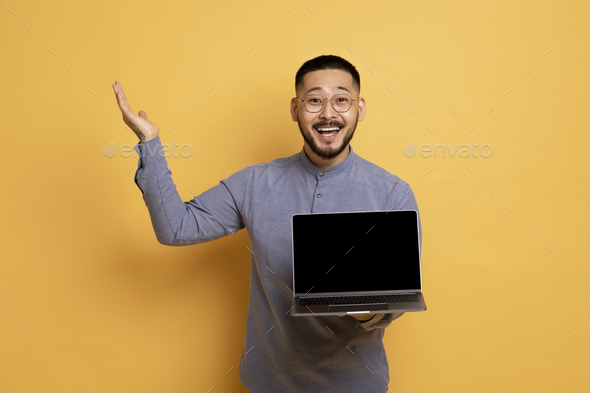 Great Website. Excited Asian Man Holding Laptop Computer With Blank Screen