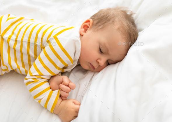 Cradle of dreams. Infant's tranquil sleep in cozy bed, kid lying on white  bedding set, closeup, free Stock Photo by Prostock-studio