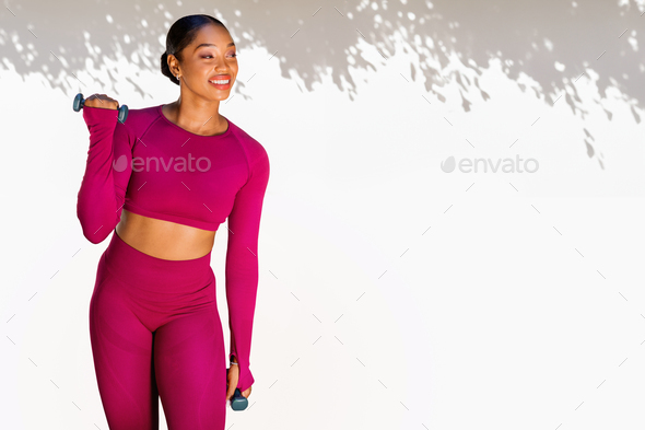 Athletic young black sportswoman exercising with dumbbells outdoor, copy space