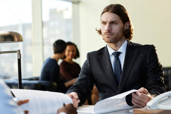Professional businessman wearing suit consulting client or partner at legal firm