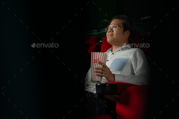 Cinema concept. People watching movie at cinema drink water and eating popcorn