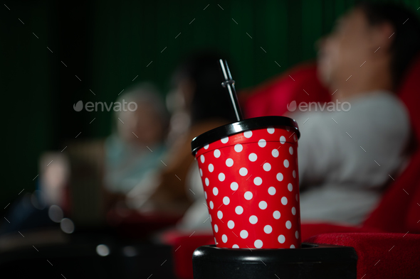 Cinema concept. People watching movie at cinema drink water and eating popcorn