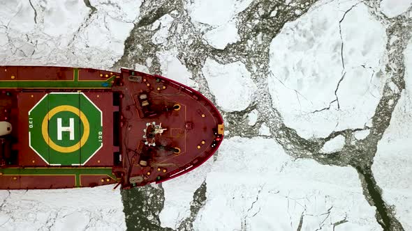 Drone Top Down Epic Red Steel Icebreaker Ship Tanker Breaks Winter Frozen Sea Overcomes alt
