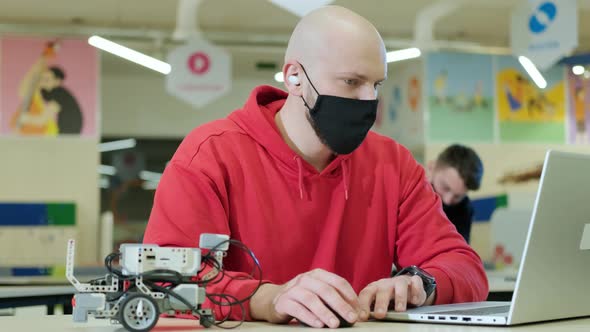 Robotics Teacher Who Teaches an Online Course for His Students Using a Computer alt