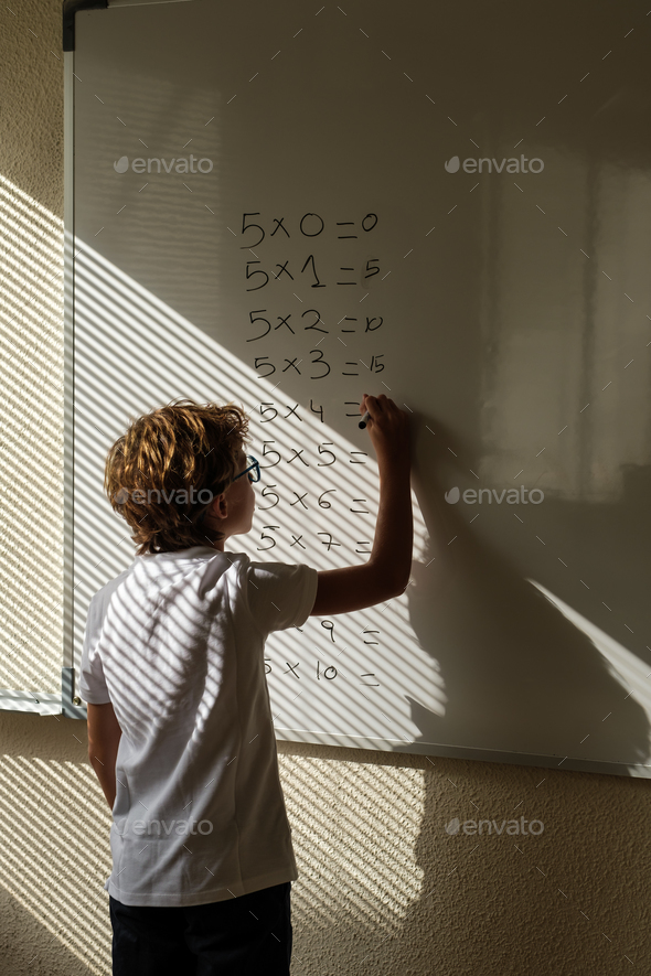 Clever pupil solving mathematical example during lesson at schoo