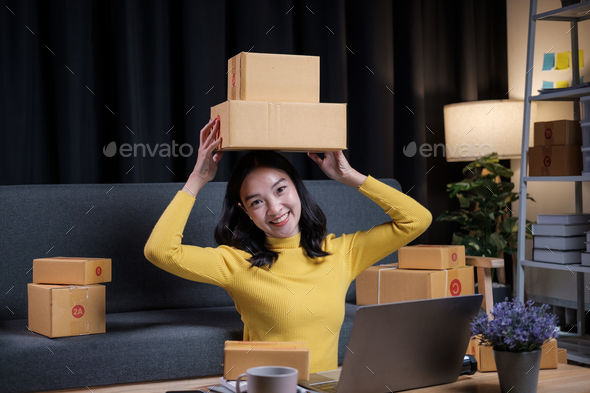 Asian female small online business shop owners were helping pack shipping orders and prepare their