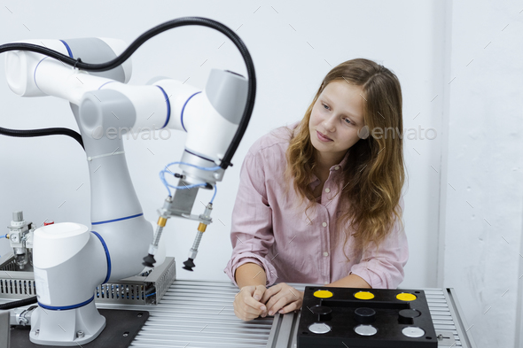 Girl caucasoid education electronic robotic arm on table at class room. learning innovation