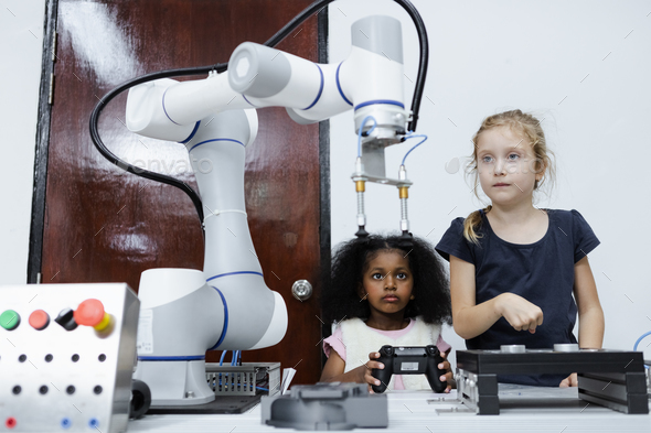Children girl caucasoid and girl African American education electronic robotic arm on table at class