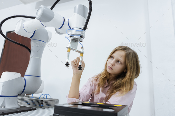 Girl caucasoid education electronic robotic arm on table at class room. learning innovation robot