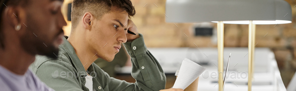 pensive man looking at documents, working in office, diverse colleagues, coworking, startup, banner