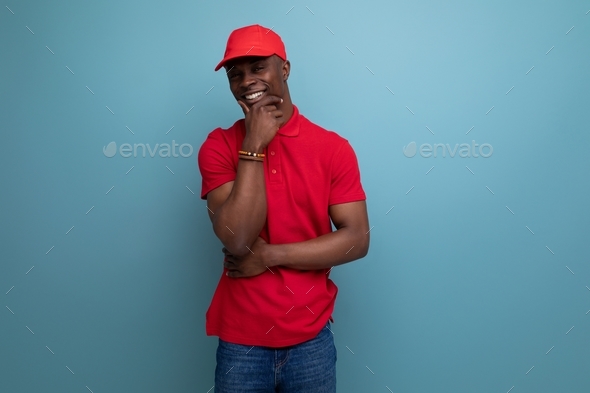 handsome young courier american man wearing corporate clothing consisting of a red cap and t-shirt
