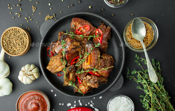 Baked ribs in a grill pan. Grilled pork ribs with spices and fresh herbs.Table background menu.