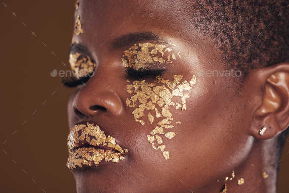 Gold, beauty and black woman with makeup for aesthetic isolated in a studio brown background eyes c