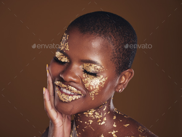 Black woman, face and gold makeup closeup with luxury dermatology and  skincare mask with glitter. Sparkle, smile and beauty with rich and shine  of cosmetics and model in a studio with facial