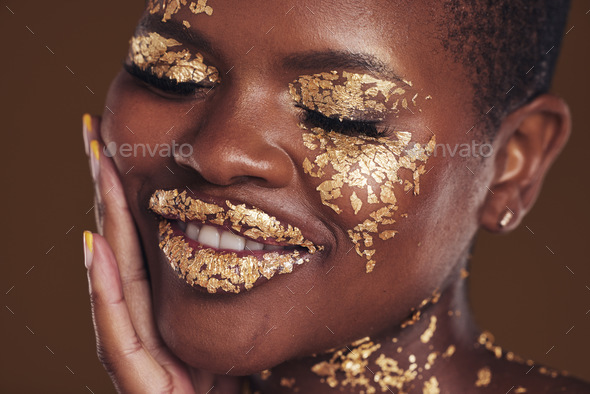 Black woman, face and gold makeup closeup with luxury dermatology and  skincare mask with glitter. Sparkle, smile and beauty with rich and shine  of cosmetics and model in a studio with facial