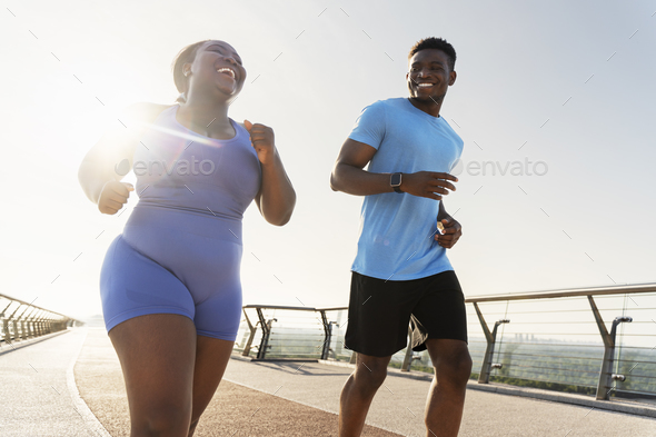African american woman running outdoors Stock Photo by