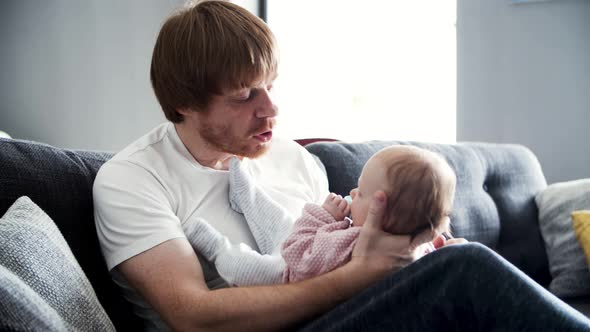 Focused Dad Holding Baby Daughter and Talking To Her alt