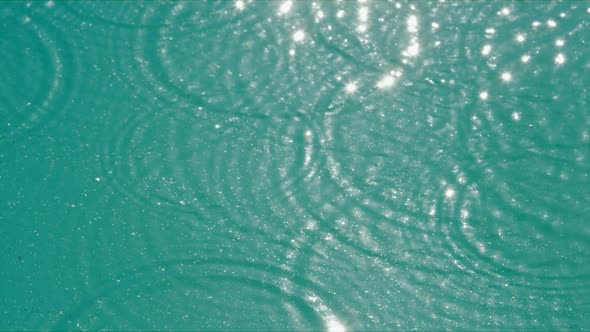 Droplets Fall Into Water Creating Small Circles of Waves alt